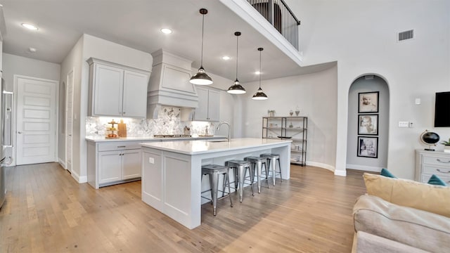 2500 Rosecroft Ct, Celina, TX 75009 - kitchen with a kitchen breakfast bar, a sink, open floor plan, baseboards, and light wood-type flooring