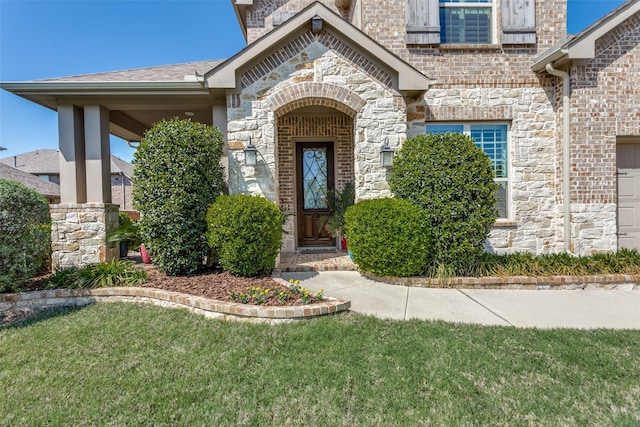 entrance to property featuring a lawn and stone siding