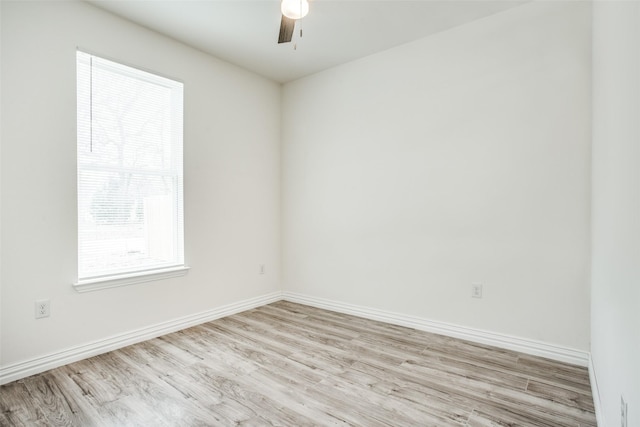 spare room with baseboards, light wood-style flooring, and a ceiling fan