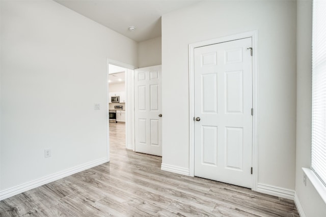 unfurnished bedroom with baseboards and light wood-style floors