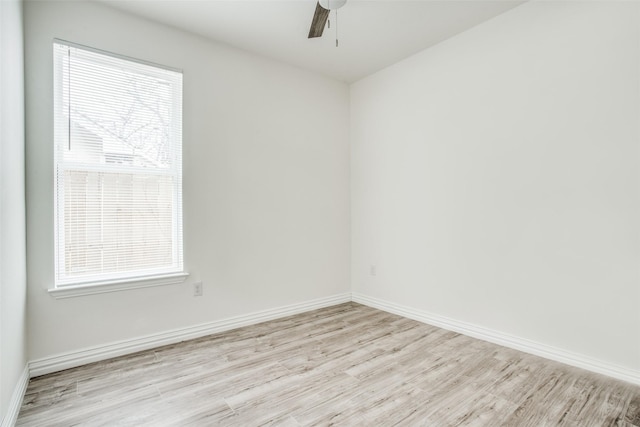 unfurnished room featuring baseboards, a wealth of natural light, light wood-style floors, and a ceiling fan