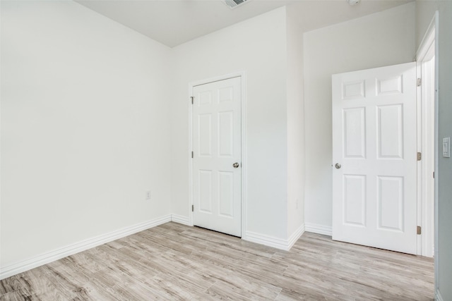 unfurnished bedroom with baseboards and light wood-type flooring