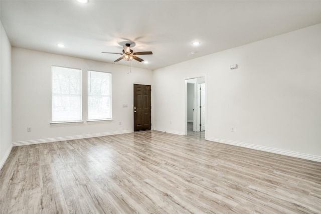 empty room featuring baseboards, light wood-style floors, and ceiling fan