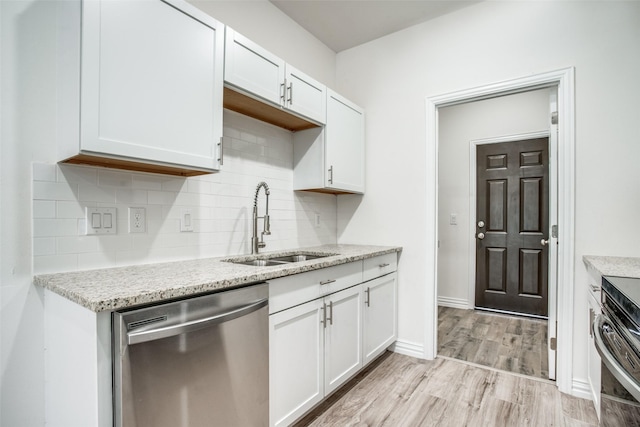 kitchen featuring white cabinetry, light wood finished floors, a sink, and dishwasher