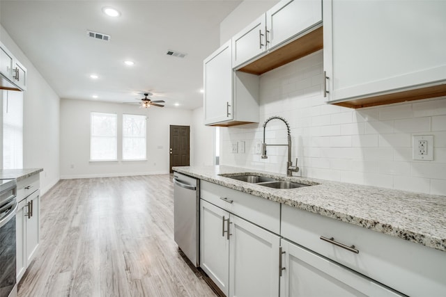 kitchen featuring a sink, a ceiling fan, stainless steel dishwasher, light wood-style flooring, and visible vents