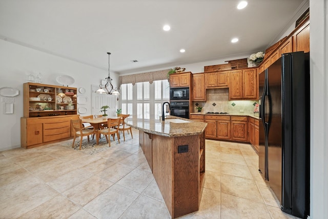 404 Creekside Dr, Murphy, TX 75094 - kitchen with light stone counters, brown cabinets, decorative backsplash, black appliances, and hanging light fixtures