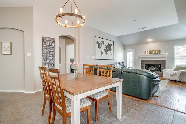 dining area with arched walkways, a wealth of natural light, visible vents, and a chandelier