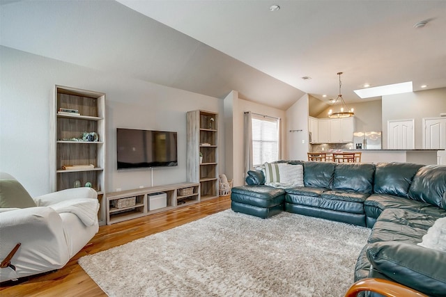 living room featuring light wood-style flooring, vaulted ceiling, a chandelier, and recessed lighting
