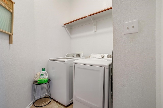 laundry room featuring a textured wall, washer and clothes dryer, and laundry area