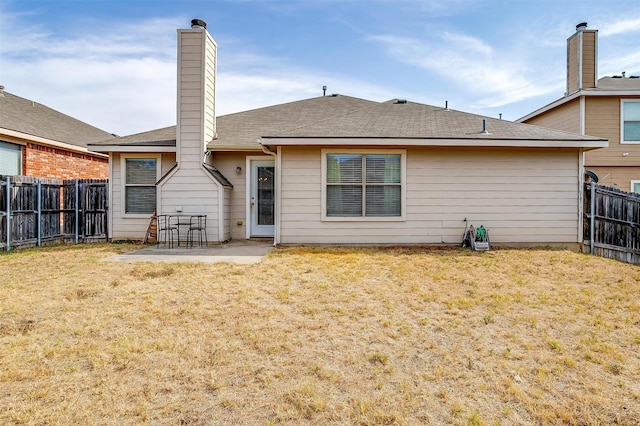 back of property with a fenced backyard, a patio area, and a yard