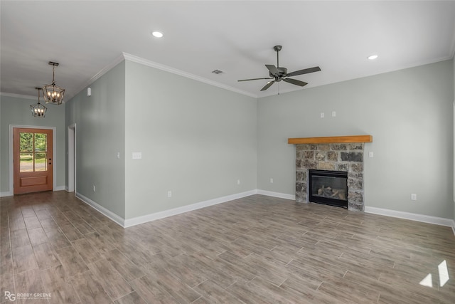 1957 Rossie Lee Dr, Bossier City, LA 71112 - unfurnished living room with wood finished floors, crown molding, ceiling fan, a chandelier, and a stone fireplace