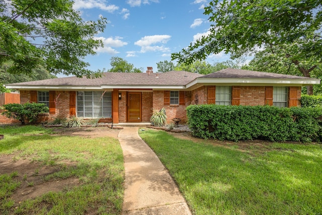 2306 Ravenwood Dr, Grand Prairie, TX 75050 - ranch-style house with brick siding, a front lawn, and a chimney