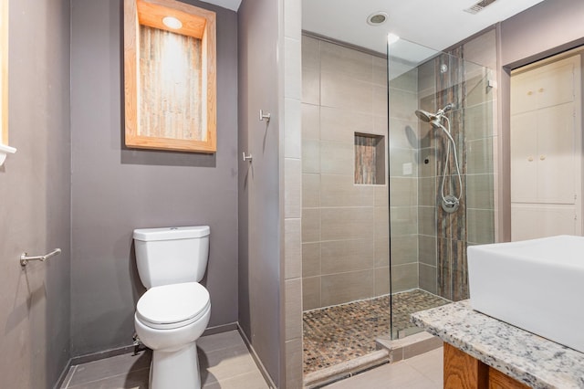 2306 Ravenwood Dr, Grand Prairie, TX 75050 - bathroom featuring a shower stall, toilet, baseboards, vanity, and tile patterned flooring