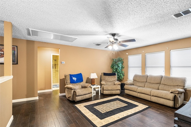 living room featuring hardwood / wood-style floors, attic access, a ceiling fan, and a textured ceiling