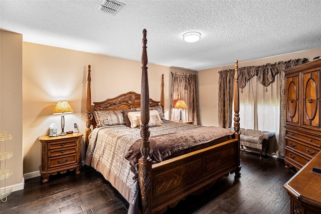 bedroom with a textured ceiling, baseboards, visible vents, and dark wood-style floors