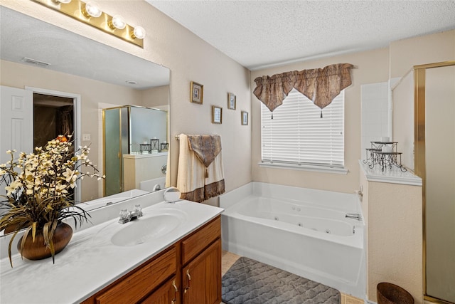 bathroom with a shower stall, a textured ceiling, vanity, a whirlpool tub, and visible vents