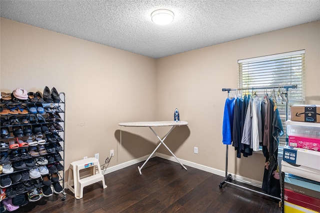 misc room featuring baseboards, wood finished floors, and a textured ceiling