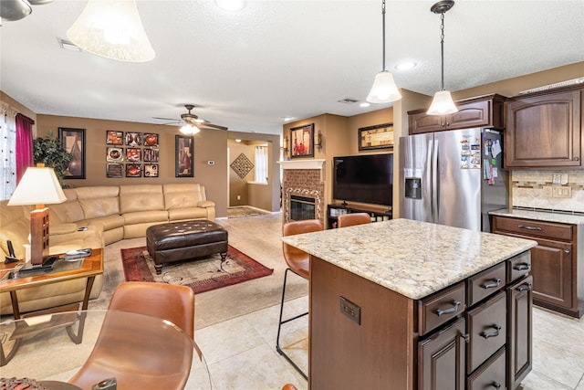 kitchen featuring stainless steel fridge, open floor plan, visible vents, light colored carpet, and ceiling fan