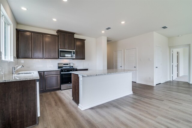3800 Parsons St, Crandall, TX 75114 - kitchen with visible vents, a kitchen island, a sink, light wood-style flooring, and stainless steel appliances