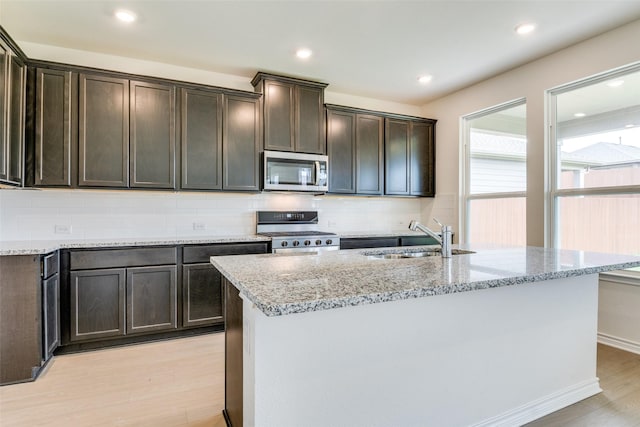 3808 Parsons St, Crandall, TX 75114 - kitchen with decorative backsplash, light stone countertops, a sink, light wood-style floors, and stainless steel appliances