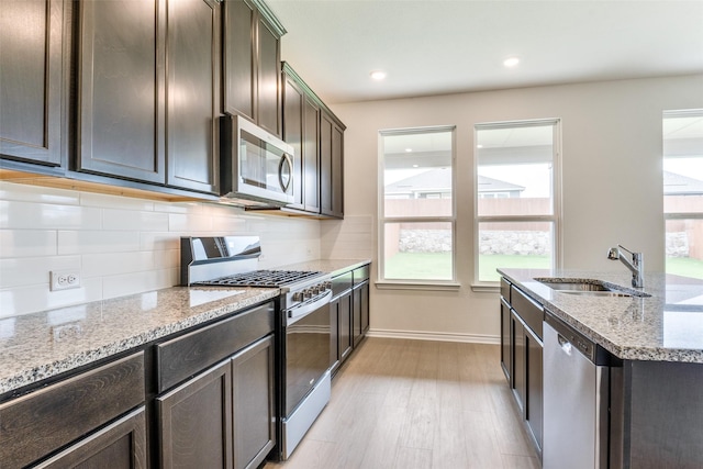 3808 Parsons St, Crandall, TX 75114 - kitchen featuring a sink, light stone counters, stainless steel appliances, and a healthy amount of sunlight