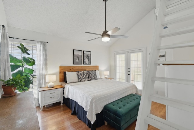 bedroom with light wood-style floors, access to exterior, multiple windows, and a textured ceiling
