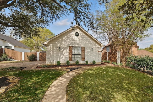 view of front of property with brick siding, fence, and a front lawn