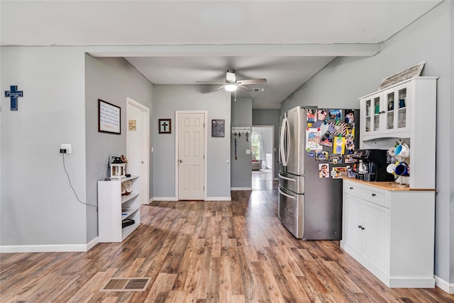 kitchen featuring baseboards, light wood-style flooring, freestanding refrigerator, white cabinets, and visible vents