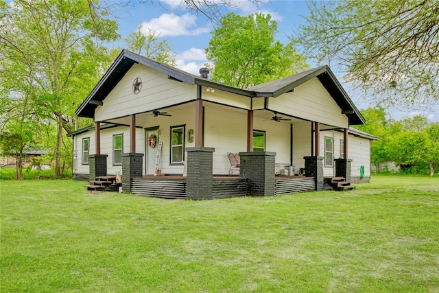 back of house featuring a porch, a ceiling fan, and a lawn