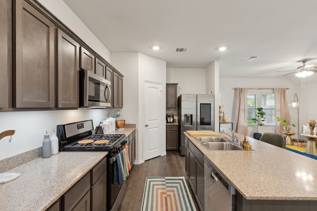 1002 Honey Maple St, Princeton, TX 75407 - kitchen with stainless steel appliances, a sink, dark wood-type flooring, dark brown cabinets, and ceiling fan