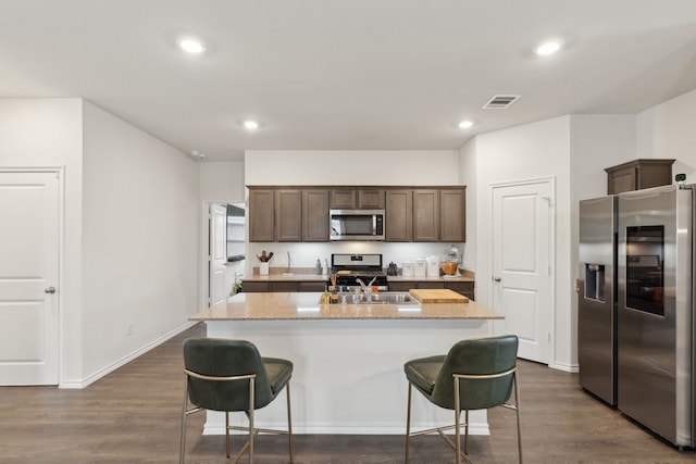 1002 Honey Maple St, Princeton, TX 75407 - kitchen with stainless steel appliances, an island with sink, a kitchen bar, recessed lighting, and dark brown cabinets