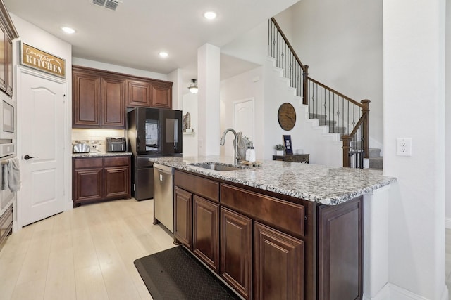 1103 Wrenwood Dr, Justin, TX 76247 - kitchen with a sink, appliances with stainless steel finishes, light wood-style floors, light stone counters, and recessed lighting