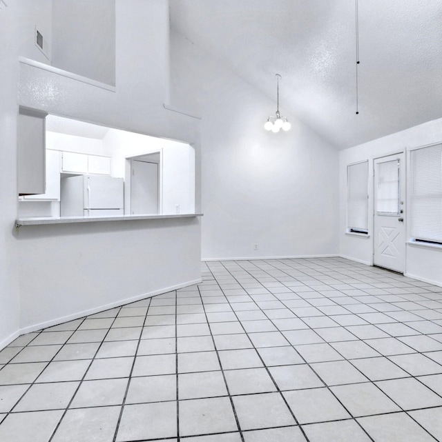 unfurnished living room with high vaulted ceiling, a textured ceiling, visible vents, baseboards, and an inviting chandelier