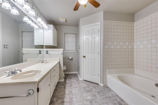 bathroom with a bathing tub, a sink, toilet, and ceiling fan