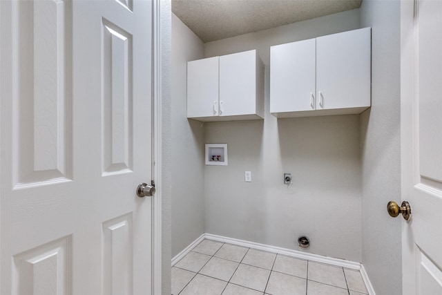 laundry area featuring light tile patterned floors, baseboards, washer hookup, cabinet space, and electric dryer hookup