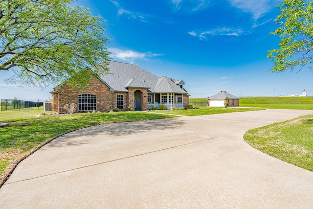 view of front of house featuring brick siding, a front yard, and fence