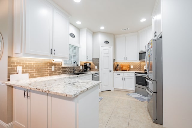 1609 W Alamosa Dr, Talty, TX 75160 - kitchen featuring a sink, appliances with stainless steel finishes, a peninsula, white cabinetry, and recessed lighting