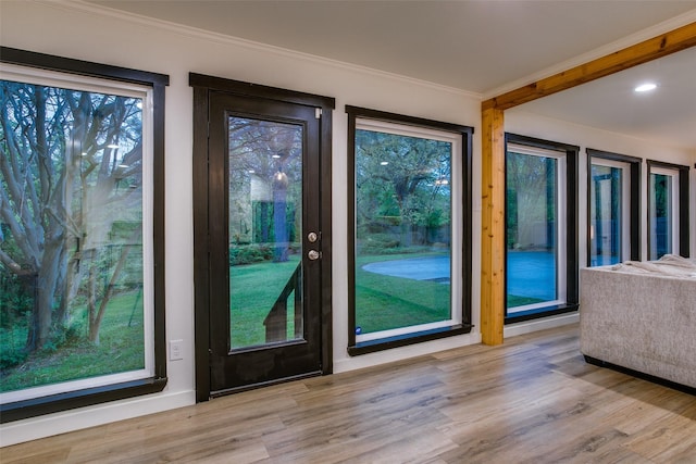 doorway to outside featuring wood finished floors and crown molding