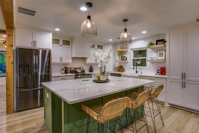 kitchen featuring open shelves, stainless steel appliances, a sink, visible vents, and white cabinets