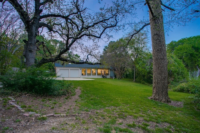 view of yard with driveway and an attached garage