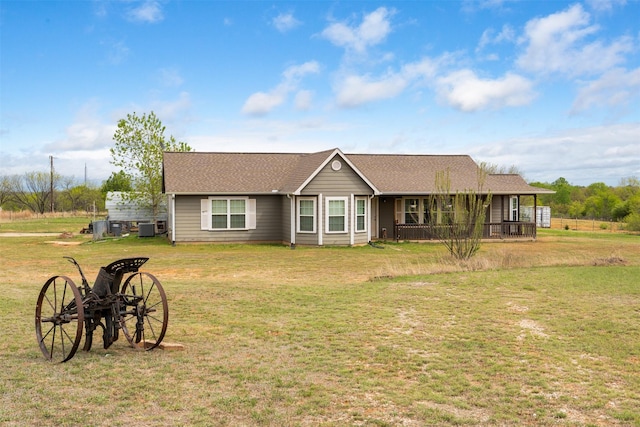 ranch-style house featuring roof with shingles and a front lawn