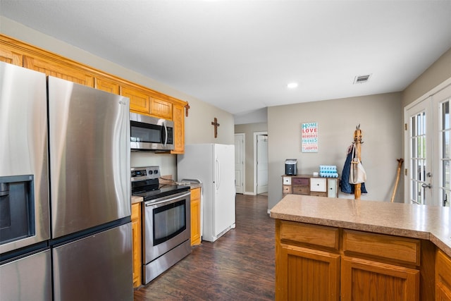 kitchen with light countertops, dark wood-style flooring, stainless steel appliances, and visible vents