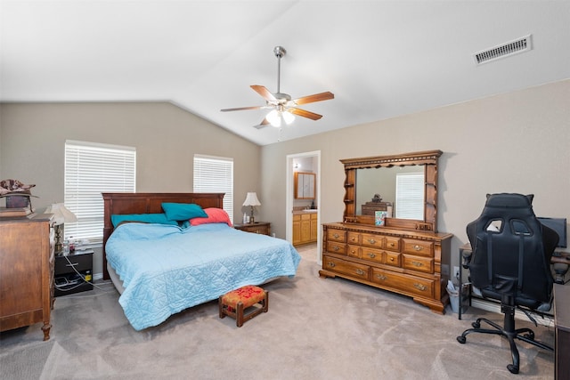 bedroom featuring lofted ceiling, ensuite bath, ceiling fan, visible vents, and light carpet