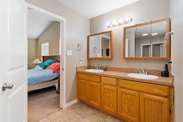 bathroom featuring double vanity, connected bathroom, a sink, and tile patterned flooring