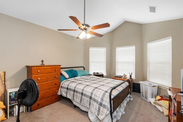 bedroom featuring light carpet, visible vents, lofted ceiling, and a ceiling fan