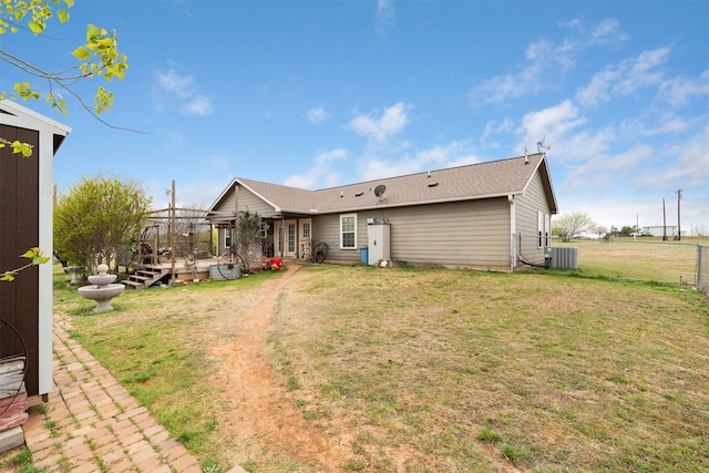 back of property with a lawn, fence, cooling unit, and a deck