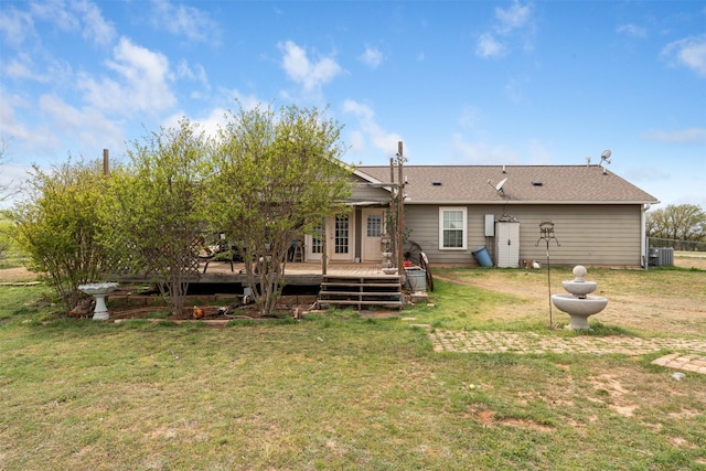 back of property with a lawn, a wooden deck, central AC, and roof with shingles