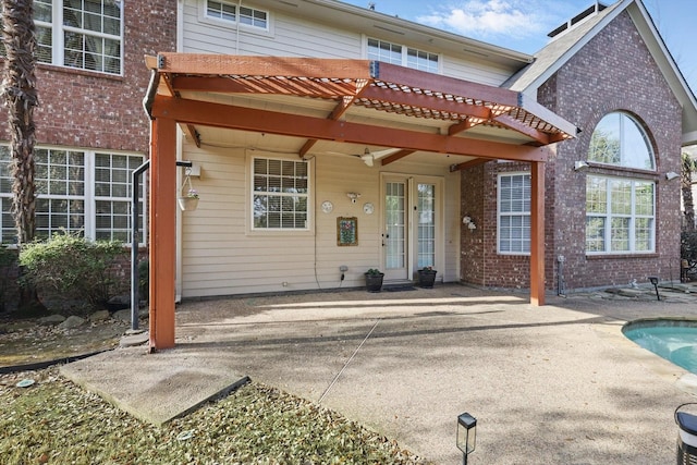 rear view of property with a pergola, a patio area, and brick siding