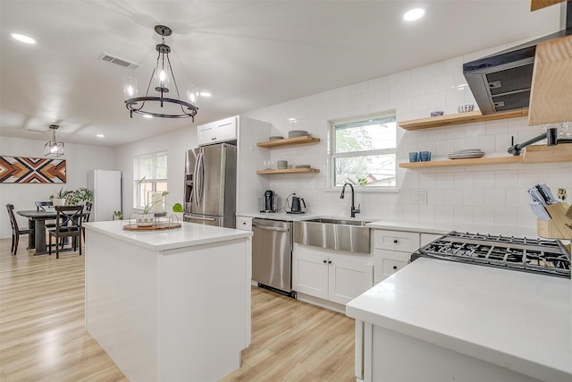 3113 Westfield Ave, Fort Worth, TX 76133 - kitchen featuring open shelves, a center island, a sink, light wood finished floors, and appliances with stainless steel finishes