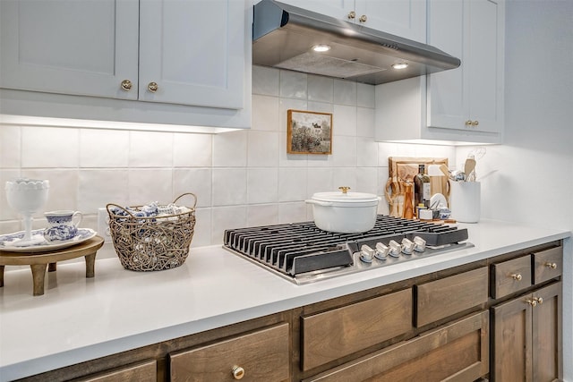 1512 Trailblazer Way, Northlake, TX 76247 - kitchen view of under cabinet range hood, stainless steel gas stovetop, backsplash, and light countertops
